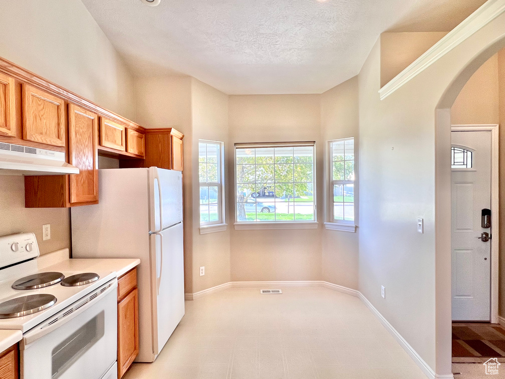 Kitchen with a textured ceiling and white electric range oven