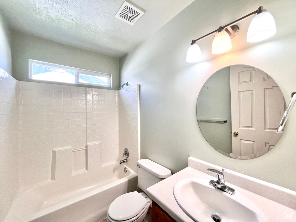 Full bathroom featuring shower / bathing tub combination, vanity, toilet, and a textured ceiling