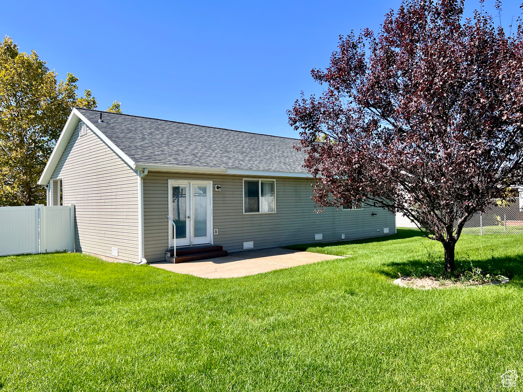 Rear view of house featuring a yard and a patio area