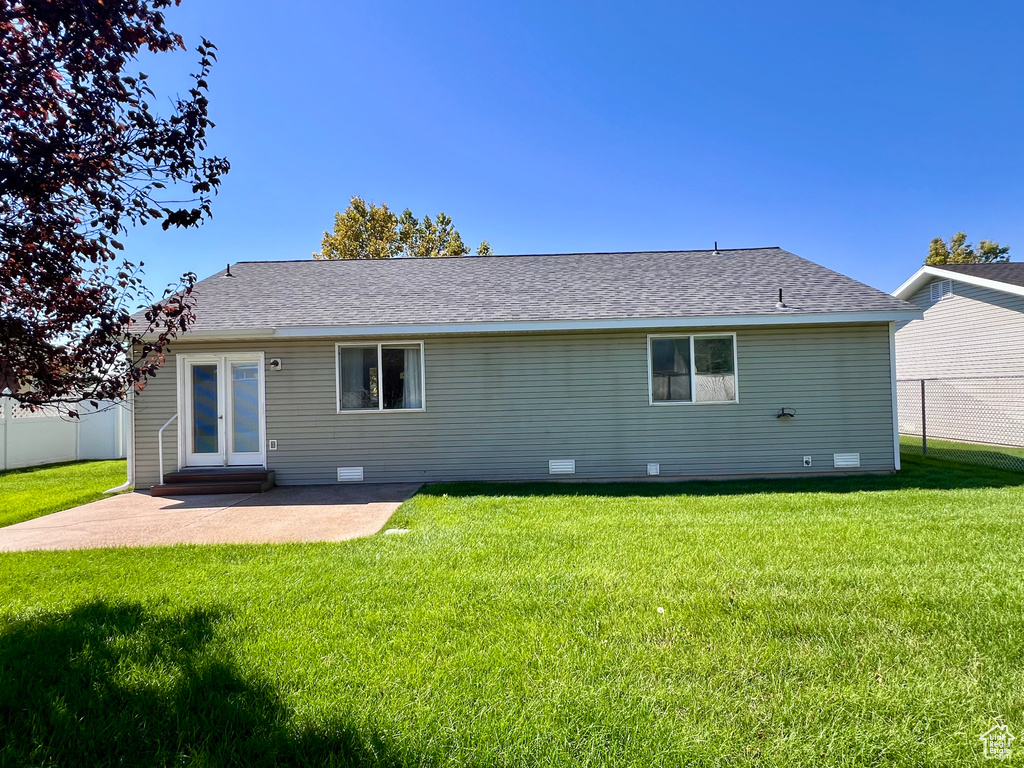 Rear view of house featuring a yard and a patio