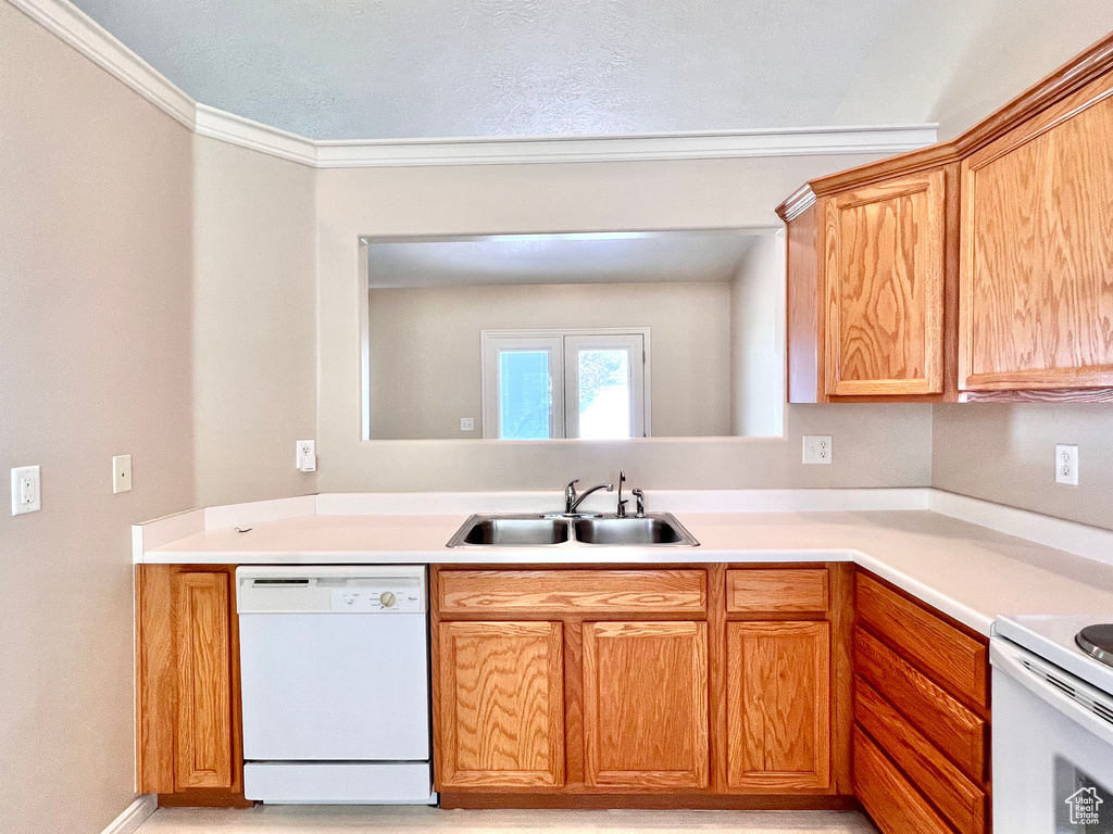 Kitchen featuring ornamental molding, white appliances, and sink