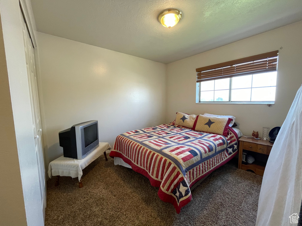 Bedroom with a textured ceiling and carpet flooring