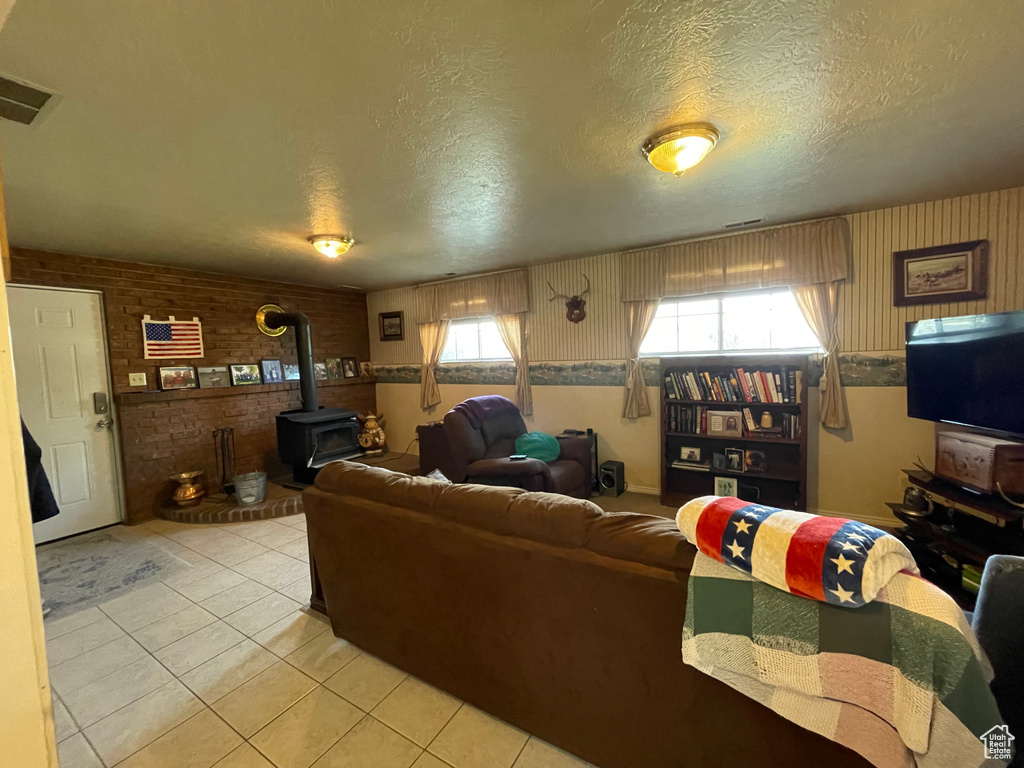 Tiled living room with a textured ceiling and a wood stove