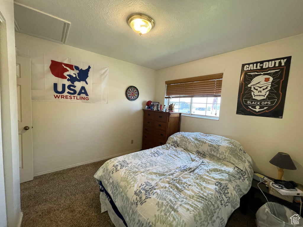 Bedroom with a textured ceiling and carpet floors