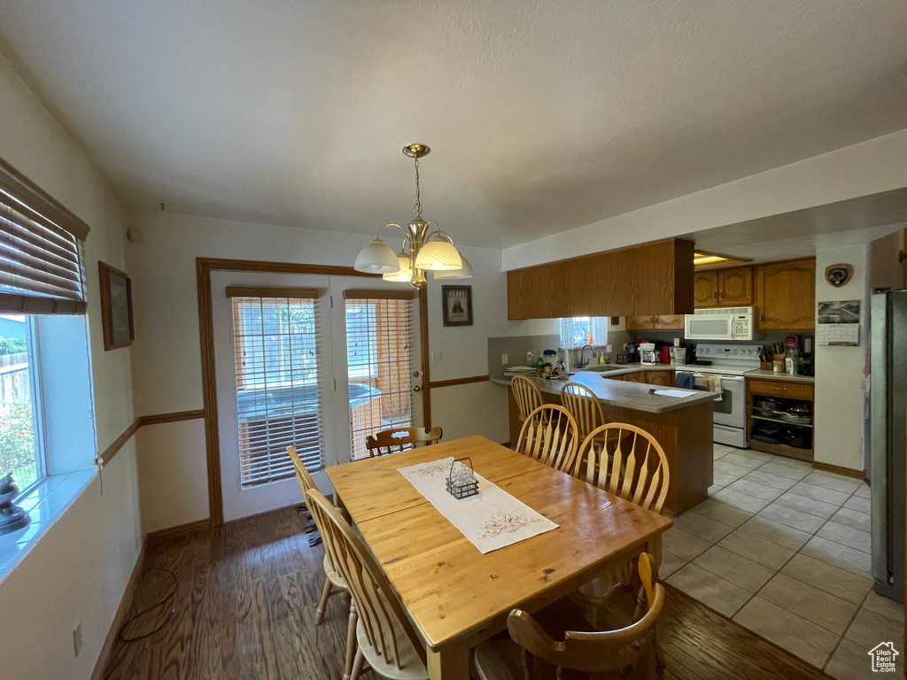 Dining space featuring a chandelier, light hardwood / wood-style floors, and a healthy amount of sunlight