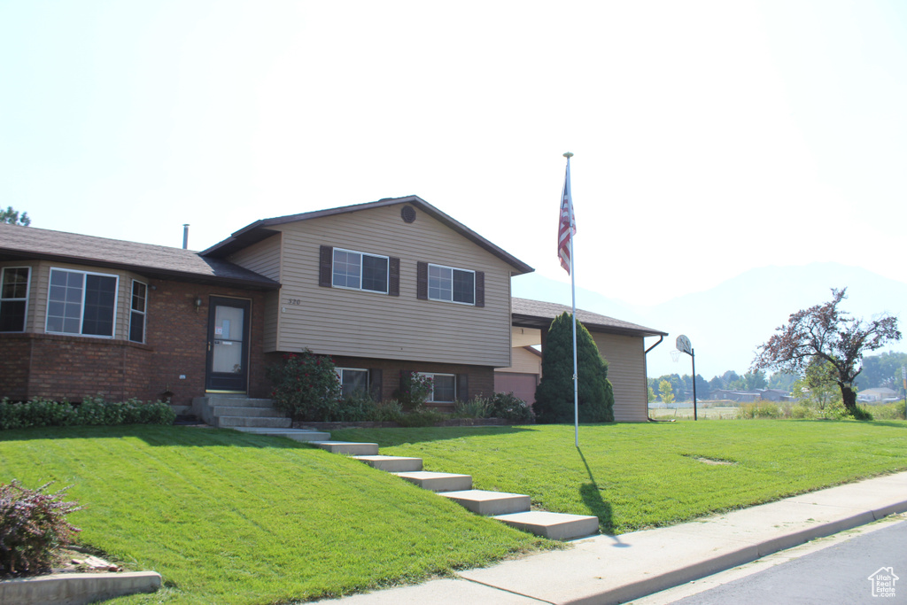 Split level home featuring a front lawn