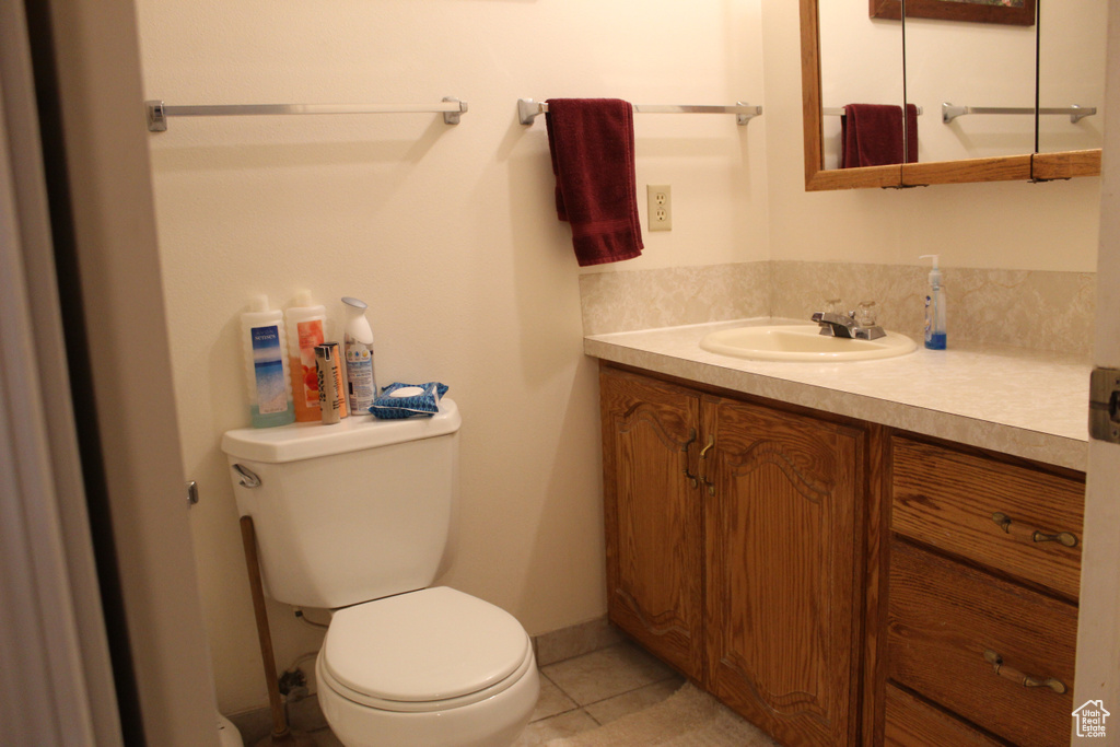 Bathroom with vanity, toilet, and tile patterned flooring