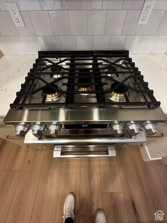 Room details featuring stainless steel gas stovetop and wood-type flooring