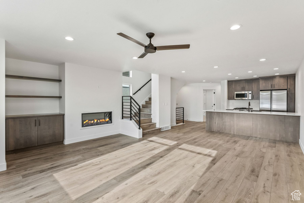 Unfurnished living room featuring light hardwood / wood-style flooring and ceiling fan