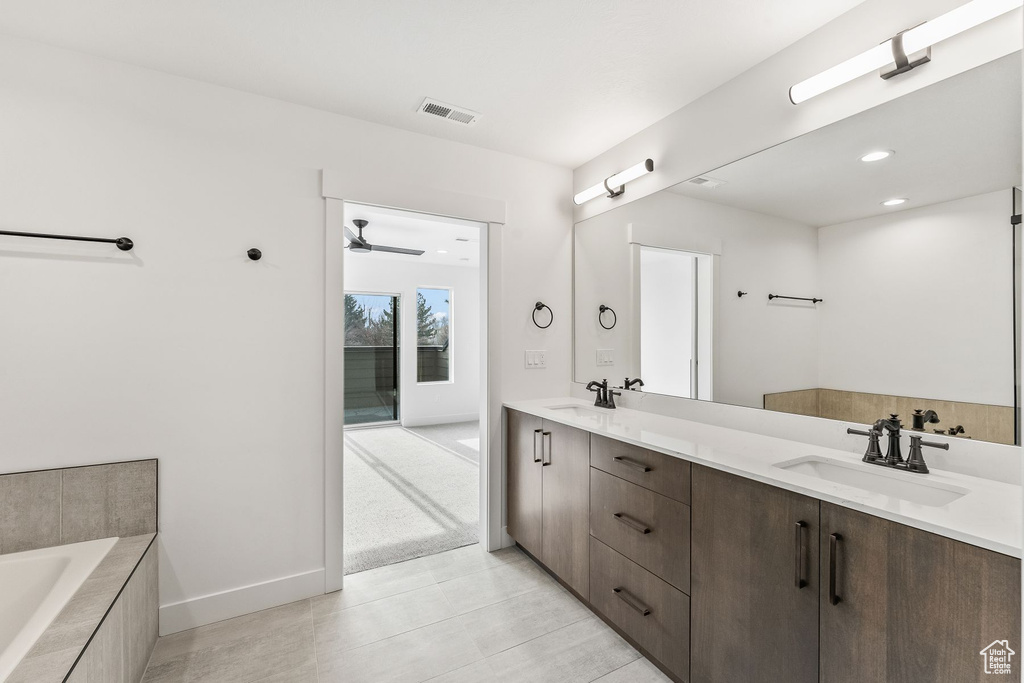 Bathroom featuring tile patterned floors, ceiling fan, a bathtub, and vanity