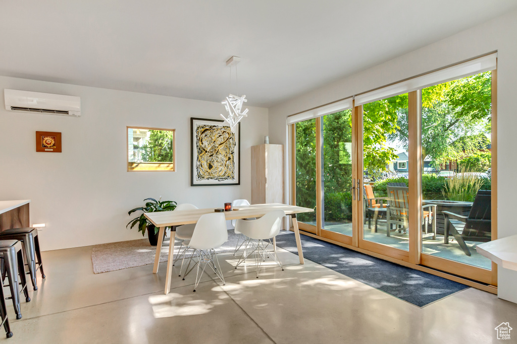 Dining space with concrete flooring and a wall mounted air conditioner