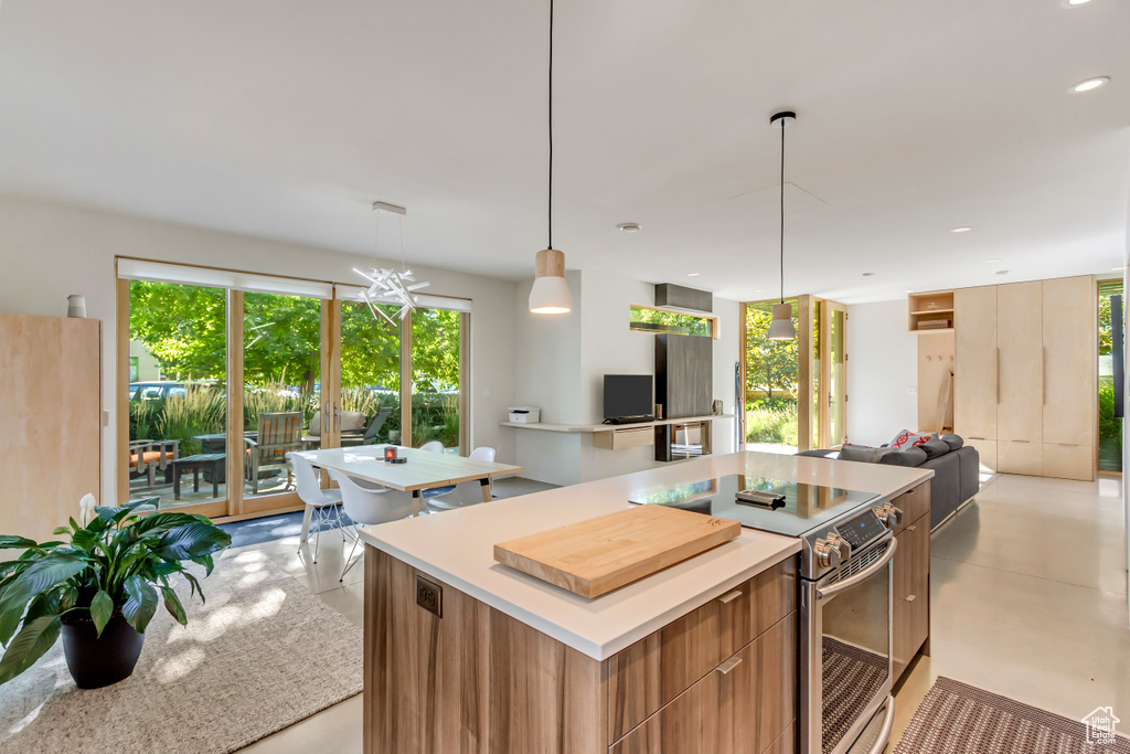 Kitchen featuring a center island, electric stove, and decorative light fixtures