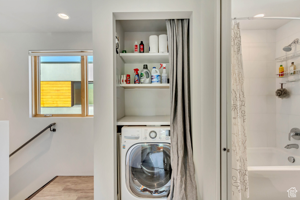 Laundry room featuring washer / dryer and light hardwood / wood-style floors