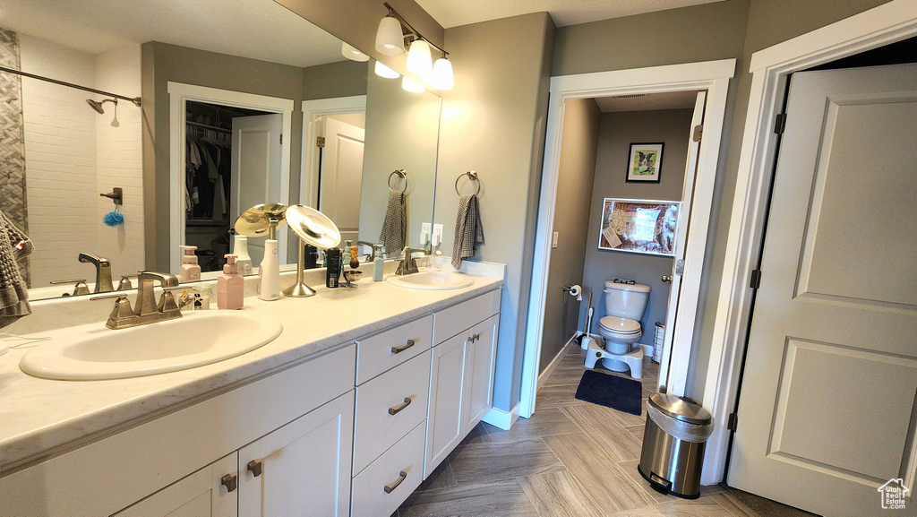 Bathroom with vanity, toilet, and a tile shower