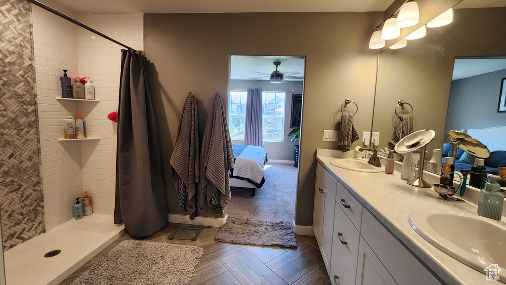 Bathroom featuring vanity, curtained shower, and ceiling fan