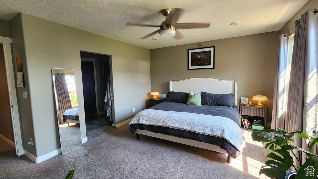 Bedroom featuring carpet flooring, ceiling fan, and a textured ceiling