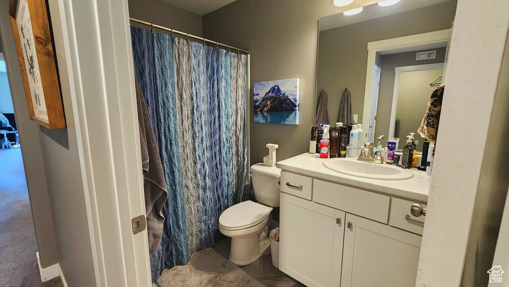 Bathroom with walk in shower, toilet, and vanity