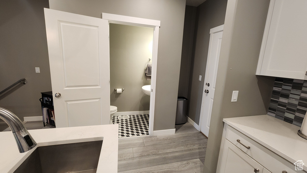 Interior space featuring light hardwood / wood-style flooring, sink, and white cabinets