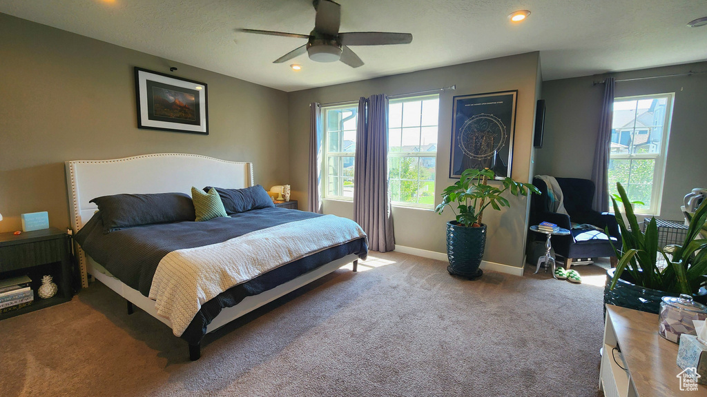 Bedroom with a textured ceiling, ceiling fan, and carpet flooring