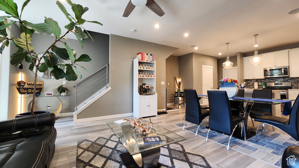 Dining space with ceiling fan, light hardwood / wood-style floors, and a textured ceiling