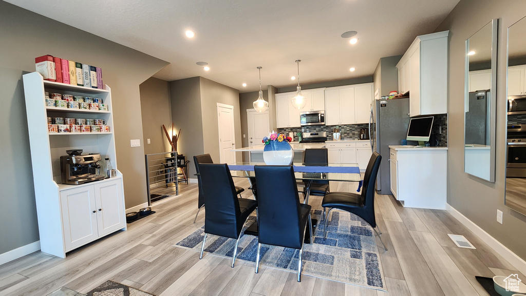 Dining space with light hardwood / wood-style flooring