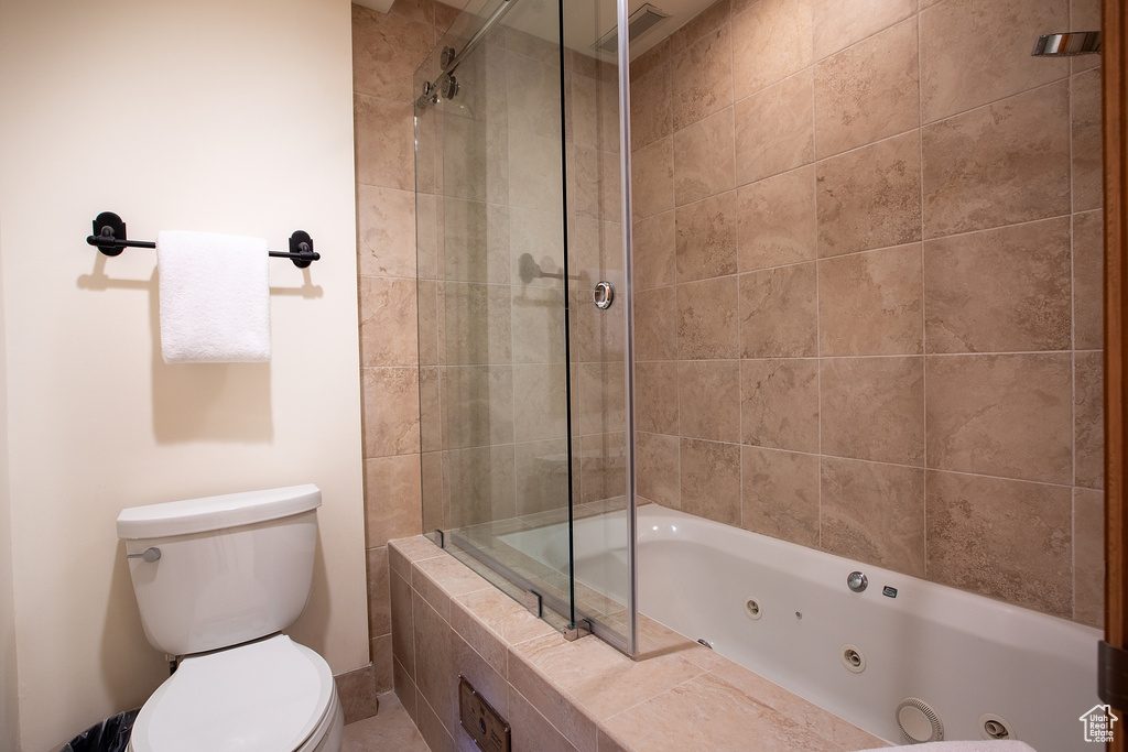 Bathroom featuring toilet and combined bath / shower with glass door