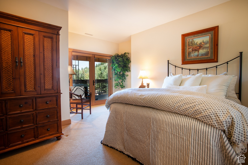 Bedroom with light colored carpet and access to outside