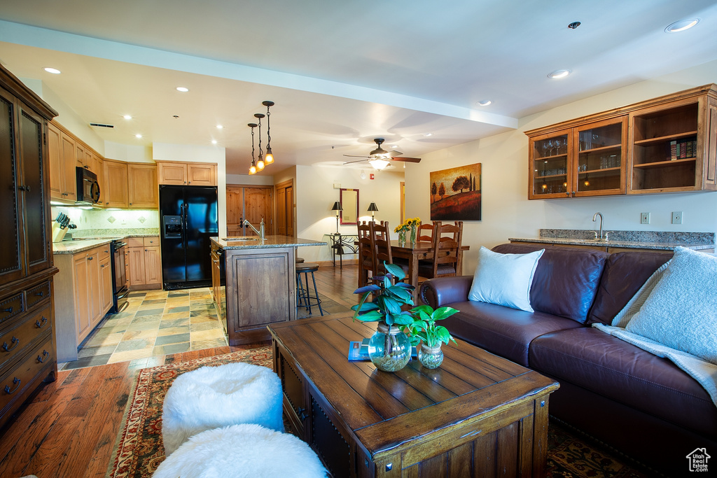 Living room with light wood-type flooring, sink, and ceiling fan