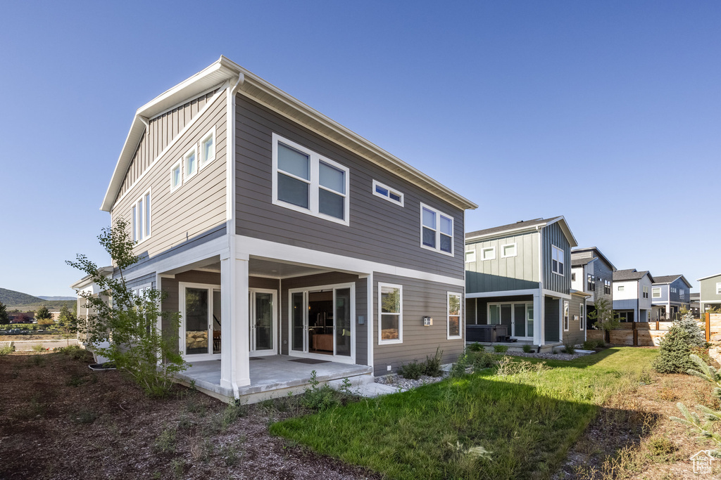 Rear view of property featuring a patio area and a lawn