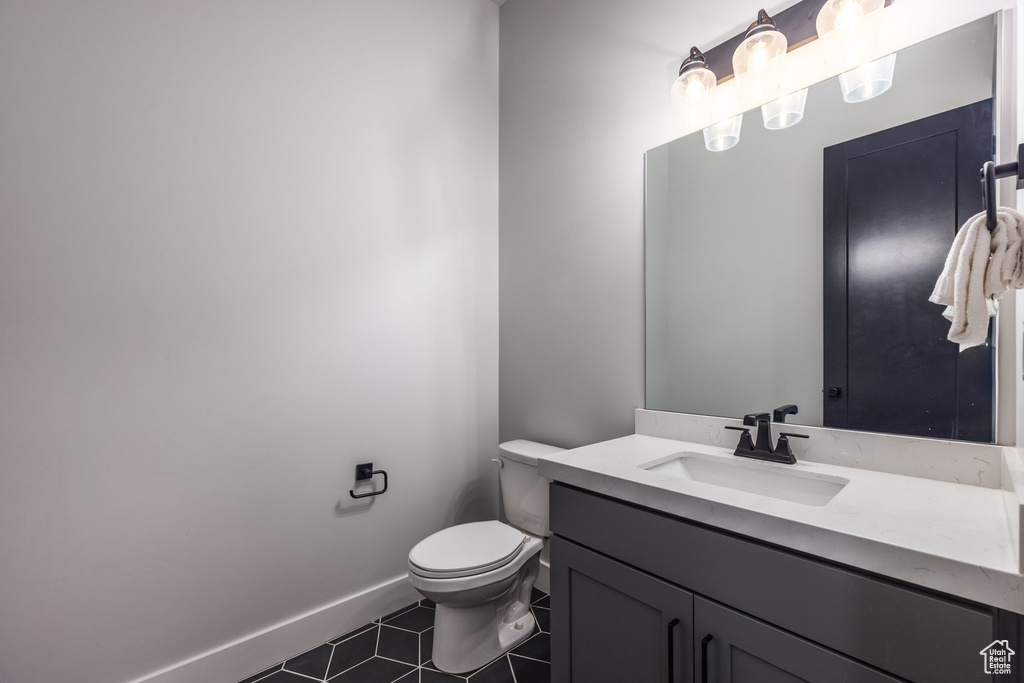 Bathroom featuring tile patterned flooring, toilet, and vanity