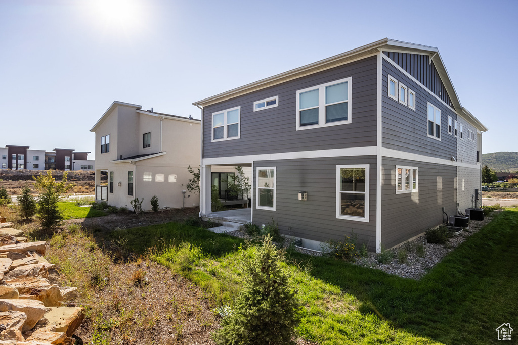 Rear view of property featuring a lawn and a patio area