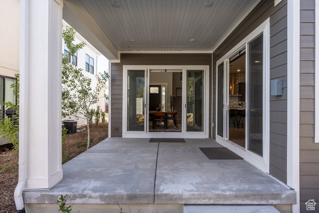 Property entrance with central AC unit and a patio area