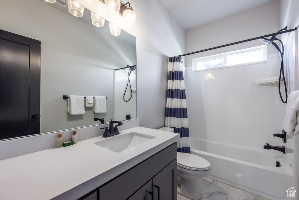 Full bathroom featuring vanity, toilet, and shower / bath combination with curtain