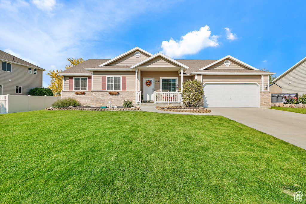 View of front facade featuring a garage and a front lawn