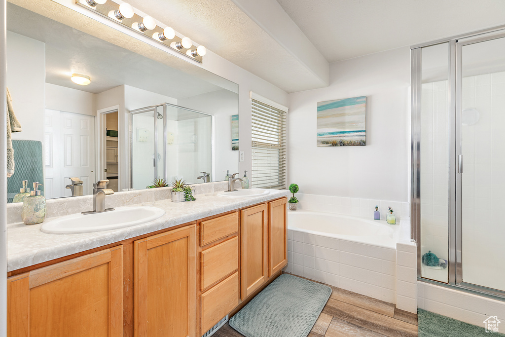 Bathroom featuring vanity, wood-type flooring, and separate shower and tub