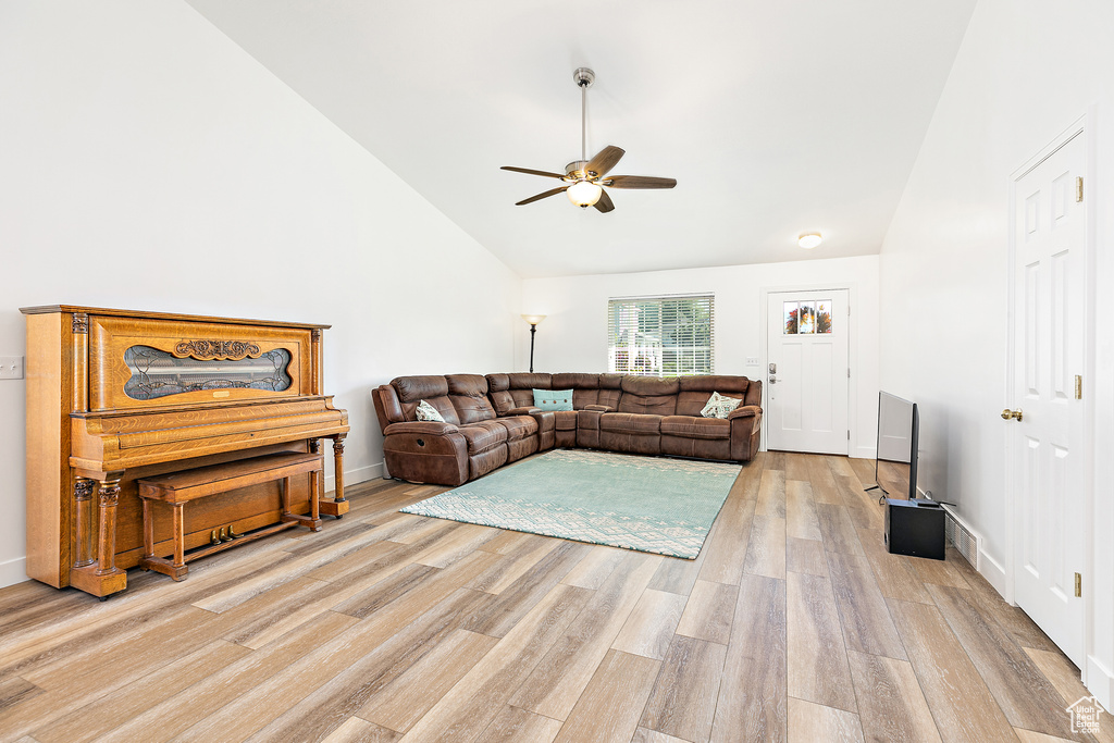 Living room featuring high vaulted ceiling, light hardwood / wood-style flooring, and ceiling fan