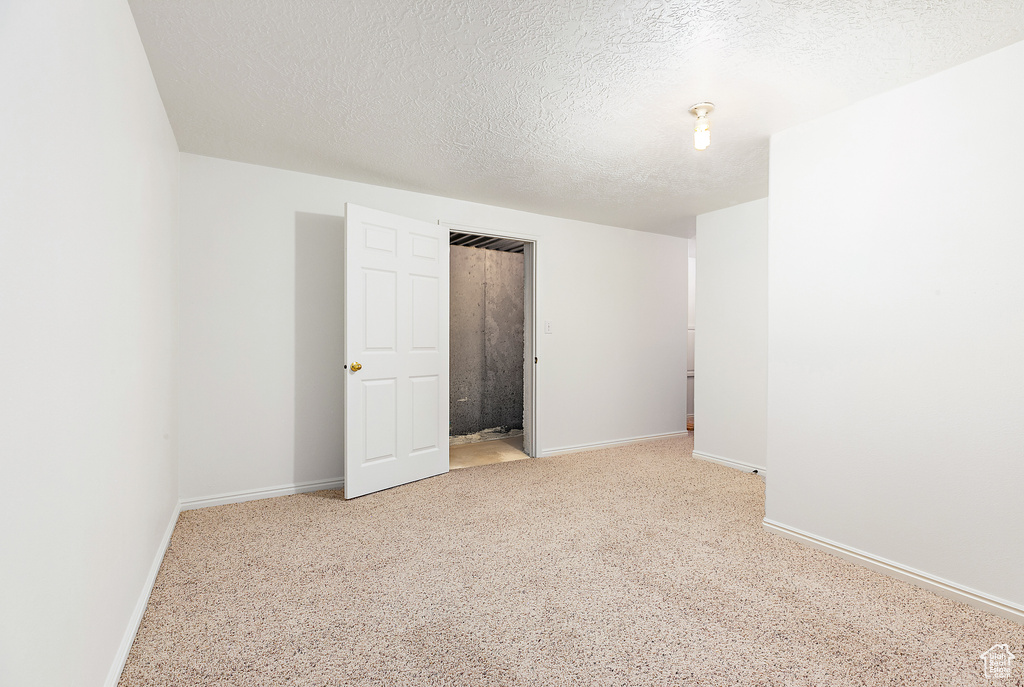 Unfurnished bedroom with light carpet and a textured ceiling