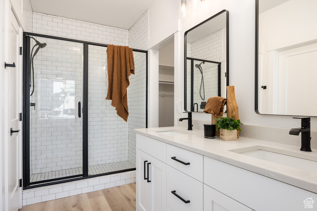 Bathroom with vanity, walk in shower, and hardwood / wood-style flooring