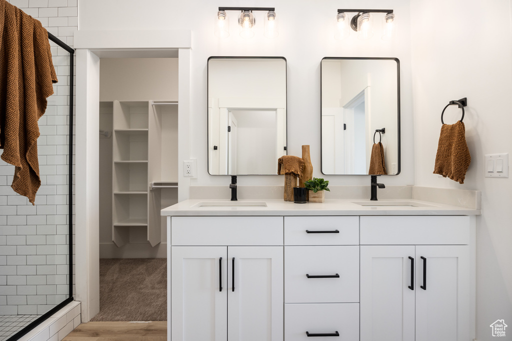 Bathroom with hardwood / wood-style floors, an enclosed shower, and vanity