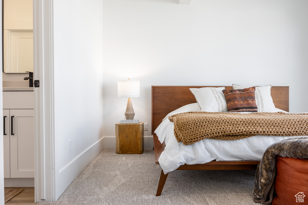 Bedroom featuring sink and light colored carpet