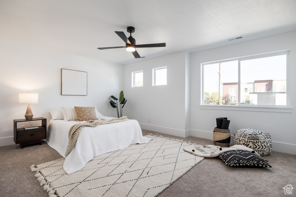 Bedroom featuring light colored carpet, ceiling fan, and a textured ceiling