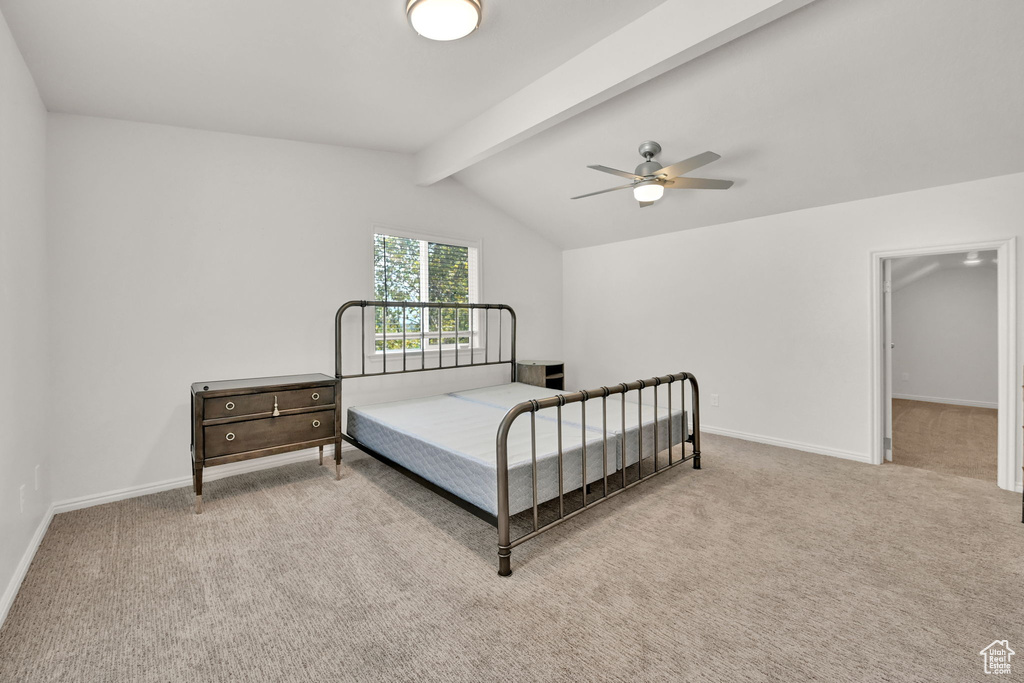 Carpeted bedroom with ceiling fan and vaulted ceiling with beams