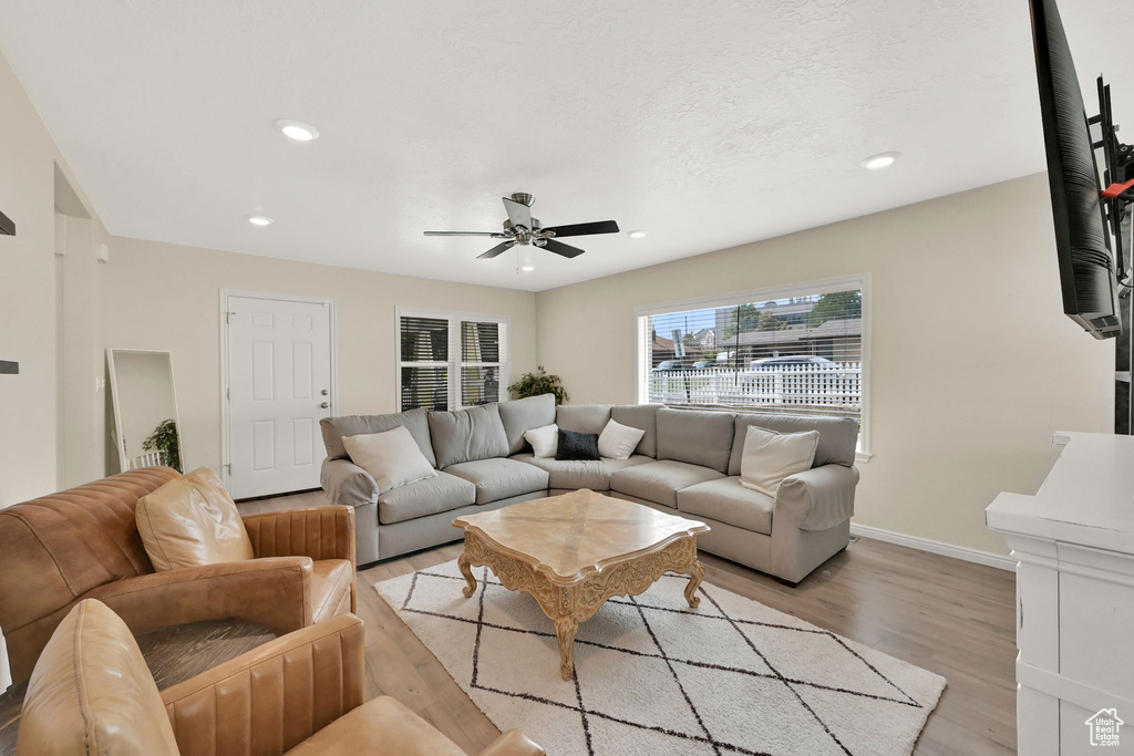 Living room with ceiling fan and light hardwood / wood-style floors