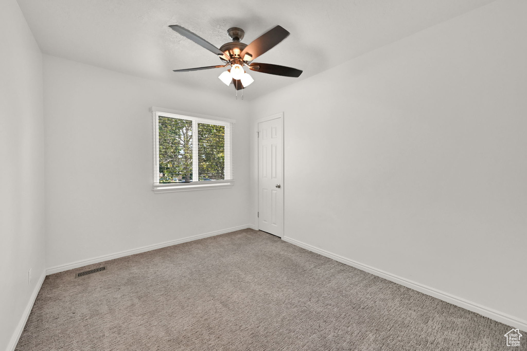 Unfurnished room featuring ceiling fan and carpet