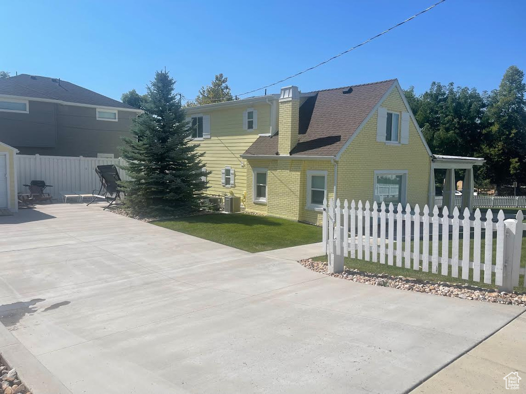 View of property exterior with a yard and central air condition unit