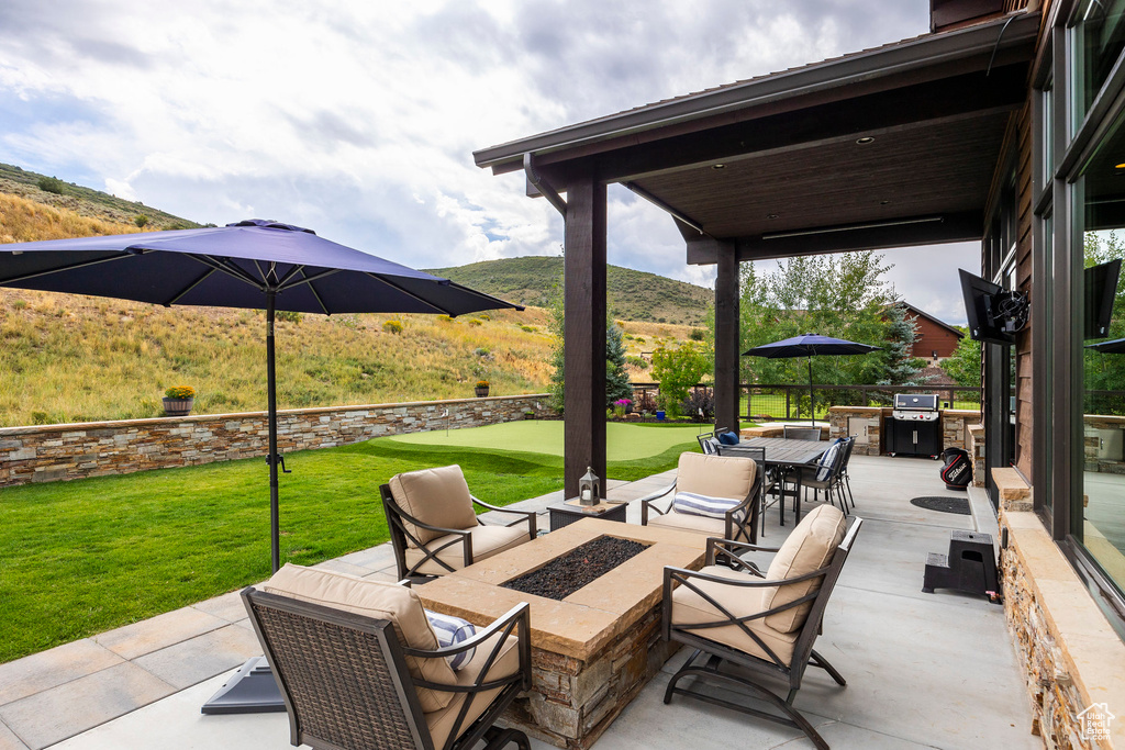 View of patio / terrace with a fire pit and grilling area
