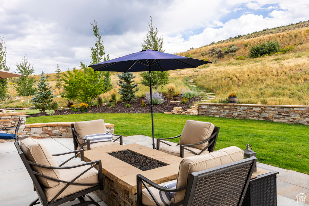View of patio featuring an outdoor living space with a fire pit