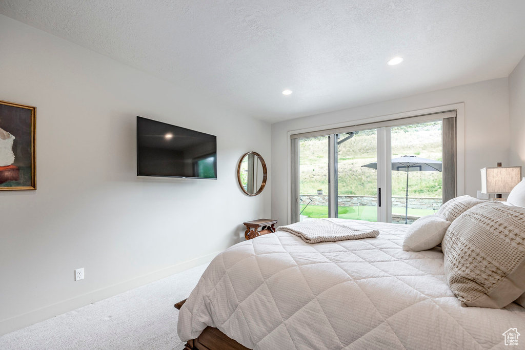 Bedroom with access to exterior, carpet, recessed lighting, baseboards, and a textured ceiling