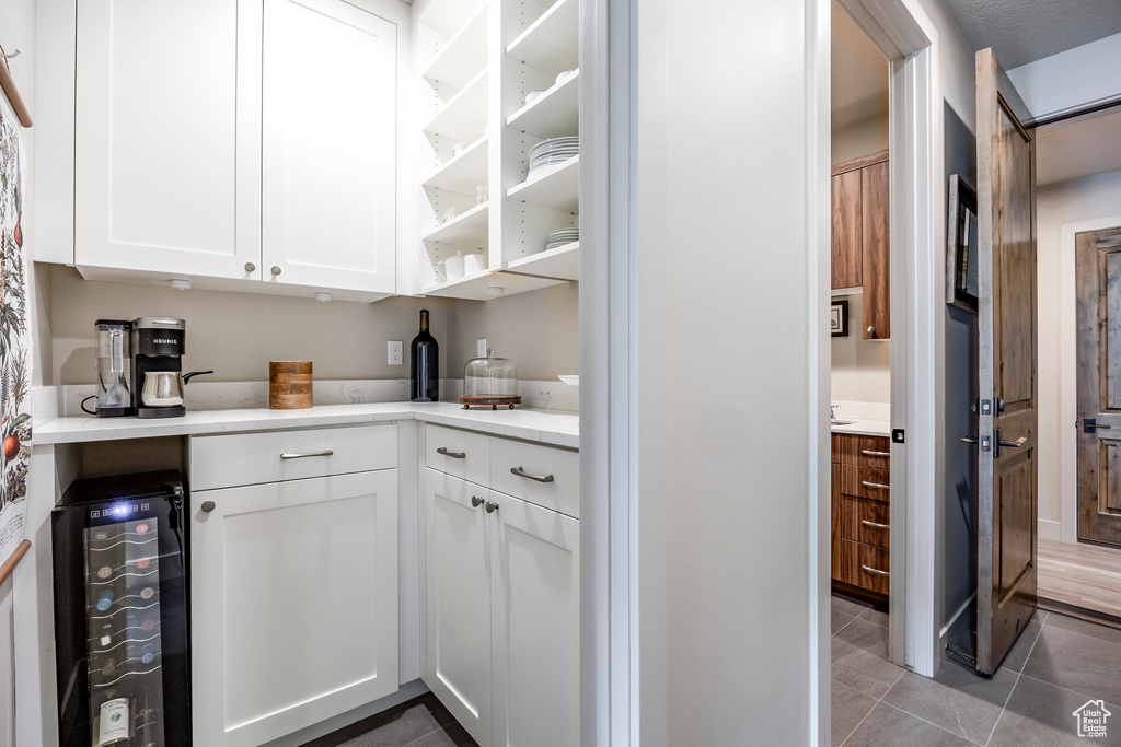Bar area featuring beverage cooler and light tile patterned floors