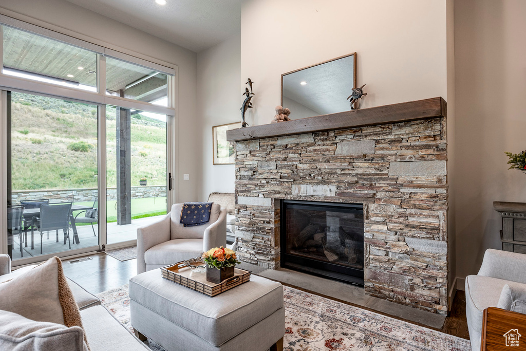 Living area with a stone fireplace, wood finished floors, and recessed lighting